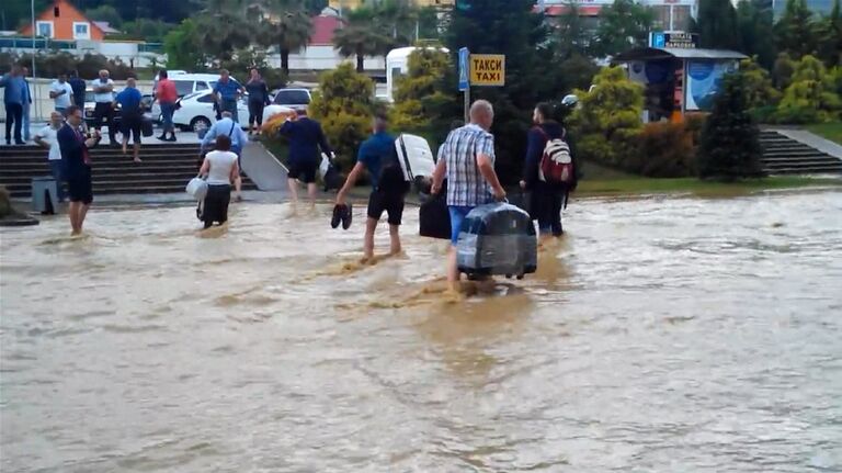 Пассажиры по колено в воде несли багаж из затопленного аэропорта Сочи