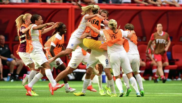 Игроки женской сборной по футболу Великобритании празднуют победу над канадками