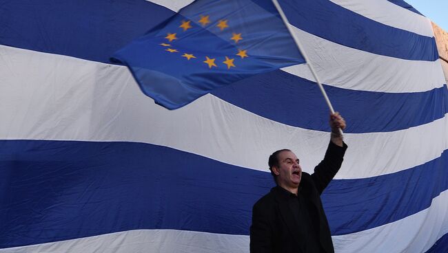 Мужчина держит флаг Евросоюза во время проевропейской демонстрации в Афинах. Архивное фото