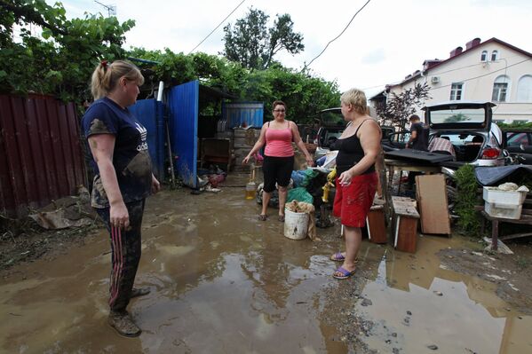 Местные жители во дворе дома, пострадавшего от подтопления после ливневых дождей в городе Сочи
