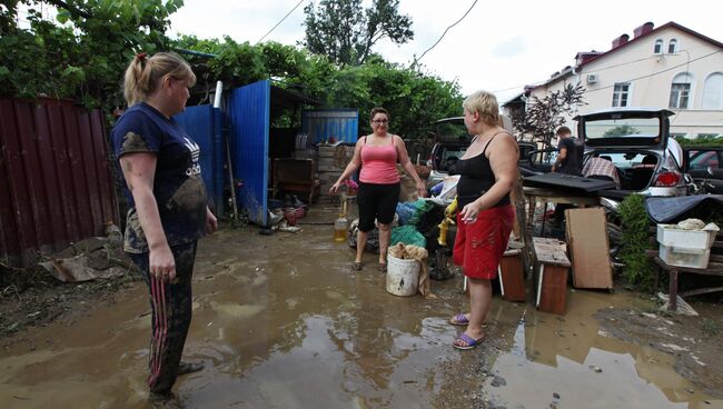 Местные жители во дворе дома, пострадавшего от подтопления после ливневых дождей в Сочи. Архивное фото