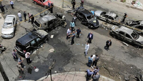 Сотрудники службы безопасности на месте взрыва автомобиля генпрокурора Египта Хишама Бараката. 29 июня 2015. Архивное фото