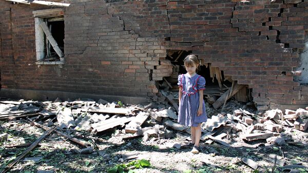 Девочка у дома, разрушенного в результате обстрела украинскими силовиками в Горловке. Архивное фото