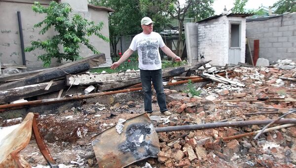 Мужчина у дома, разрушенного в результате обстрела украинскими силовиками в Октябрьском районе Донецка. Архивное фото