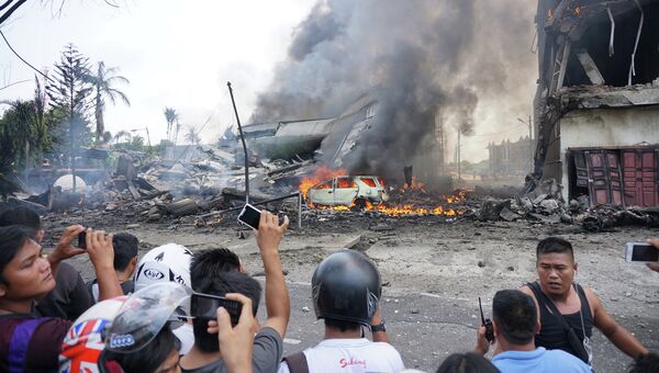 Местные жители на месте крушения военно-транспортного самолета Геркулес в Медане, Северная Суматра, Индонезия