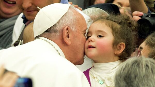 Папа Франциск целует ребенка