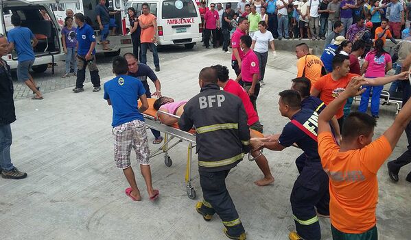 Спасатели несут пассажира затонувшего парома в Маниле, Филиппины