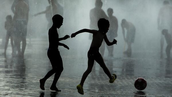 Дети играют в фонтане во время жары в Мадриде, Испания. Архивное фото