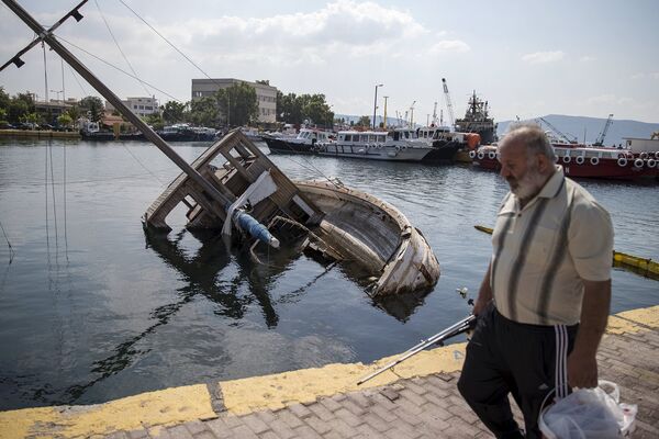 Затопленная лодка на пристани в городе Элевсин, Греция. Июнь 2015