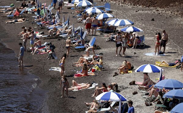 Туристы на пляже в Санторини. Греция, июнь 2015