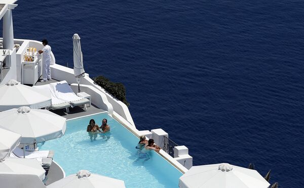 Туристы отдыхают в бассейне. Остров Санторини, Греция. Июнь 2015