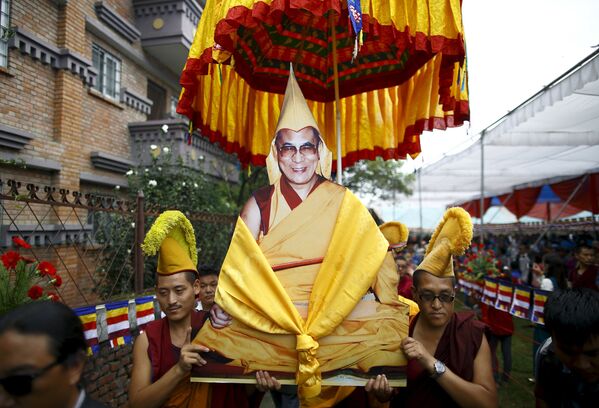Тибетские монахи несут портрет Далай-ламы во время празднования его 80-го дня рождения в Катманду