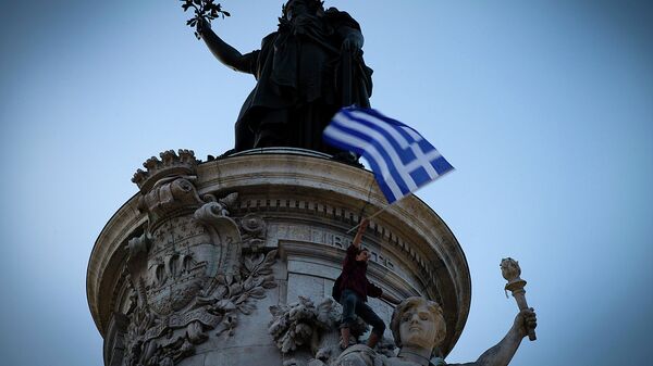 Человек с греческим флагом на площади Синтагма в Афинах 