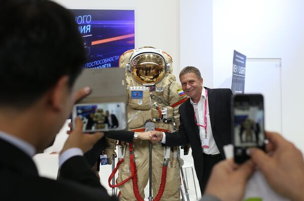 Посетитель фотографируется со скафандром на стенде Роскосмоса на Международной промышленной выставке Иннопром 2015
