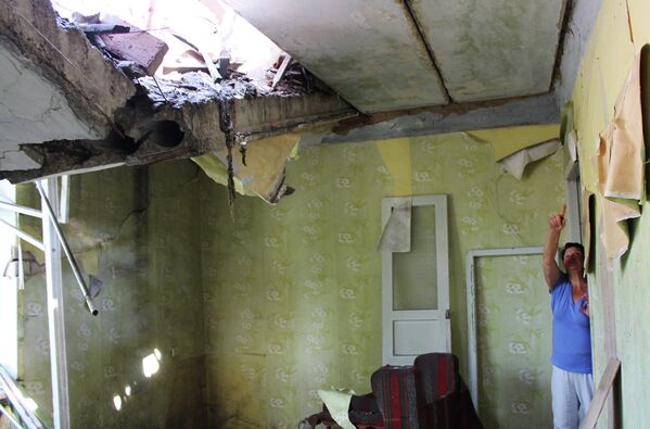 Женщина показывает разрушения своей квартиры от попадания снаряда, Дебальцево, Украина