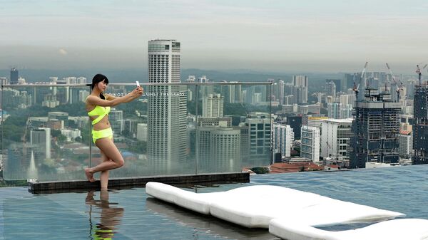 Посетительница бассейна на крыше небоскреба в Сингапуре. Архивное фото