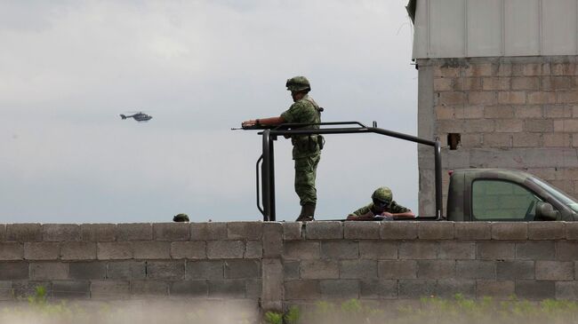 Солдаты охраняют здание недалеко от тюрьмы строгого режима в Альтиплано, Мексика