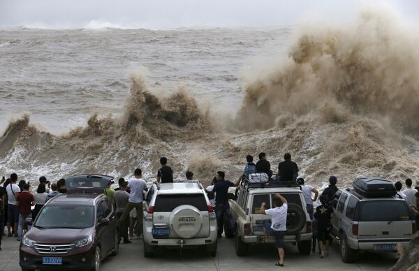 Местные жители наблюдают за волнами во время прохождения тайфуна Чан-Хом в Венлинге, Китай
