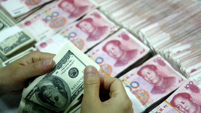 Доллары рядом с пачками юаней. Архивное фото