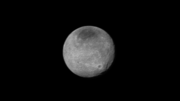 Фотография камеры LORRI, на которой можно увидеть каналы (справа) и крупный кратер на Хароне