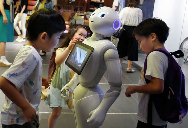 Дети окружили робота Pepper в магазине Токио, Япония. Июль 2015