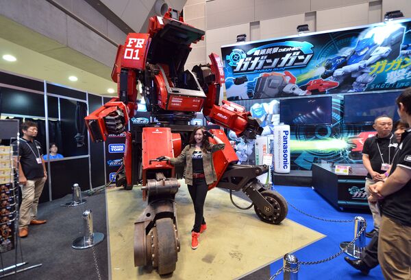 Модель позирует с роботом Kuratas на выставке Tokio Toy Show, Япония. Июнь 2015 год