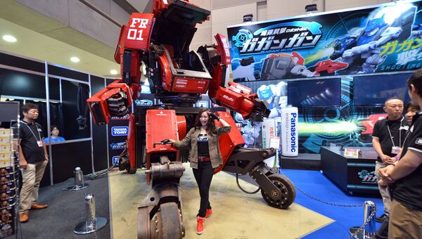 Модель позирует с роботом Kuratas на выставке Tokio Toy Show, Япония. Июнь 2015 год