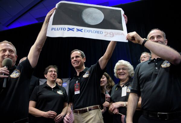 Доктор Аллан Стерн главный исследователь миссии New Horizons к Плутону с снимком планеты в Лаборатории прикладной физики Университета Джонса Хопкинса