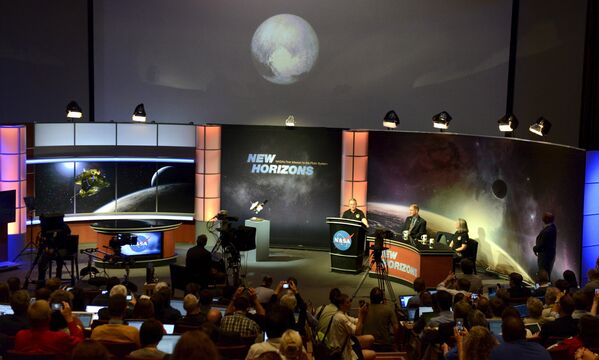 Представители СМИ во время просмотра изображения Плутона на экране в Лаборатории прикладной физики НАСА
