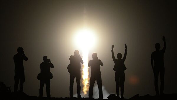 Люди наблюдают за запуском ракеты-носителя Союз-ФГ с космодрома Байконур. Архивное фото