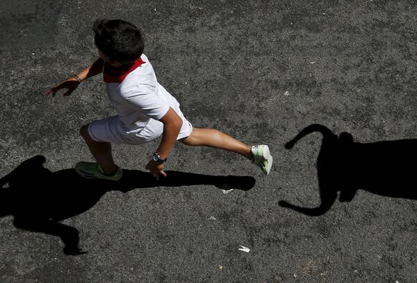 Мальчик убегает от игрушечного быка во время фестиваля Сан-Фермин в Памплоне. Испания, июль 2015