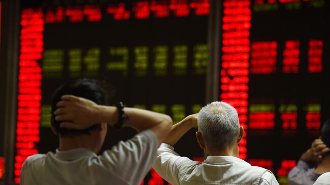 Инвесторы следят за котировками фондового рынка Китая в Пекине. Архивное фото