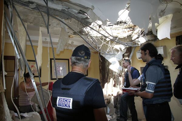 Сотрудники миссии ОБСЕ осматривают квартиру в Донецке, разрушенную в результате обстрела