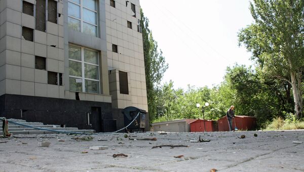 Мужчина убирает мусор у здания, поврежденного в результате ночного обстрела Донецка. Архивное фото