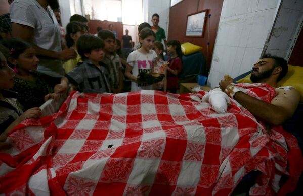 Дети у раненого боевика оппозиции в одном из пригородов Дамаска, Сирия
