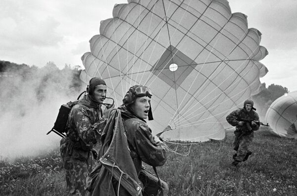 Воины-десантники приземляются с парашютом во время боевой учебы