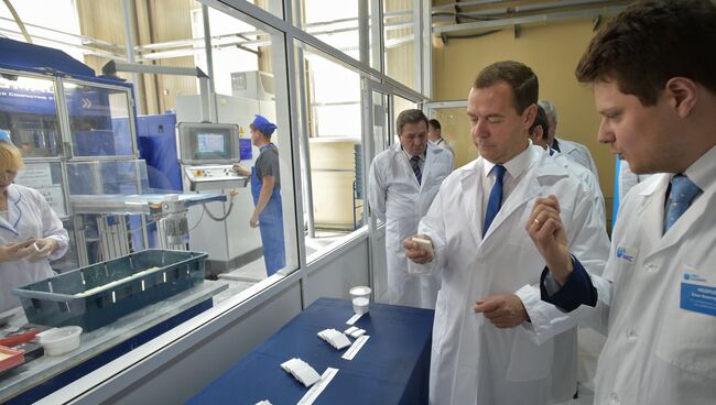 Председатель правительства России Дмитрий Медведев (в центре) во время посещения АО НЭВЗ-Керамикс в Новосибирске
