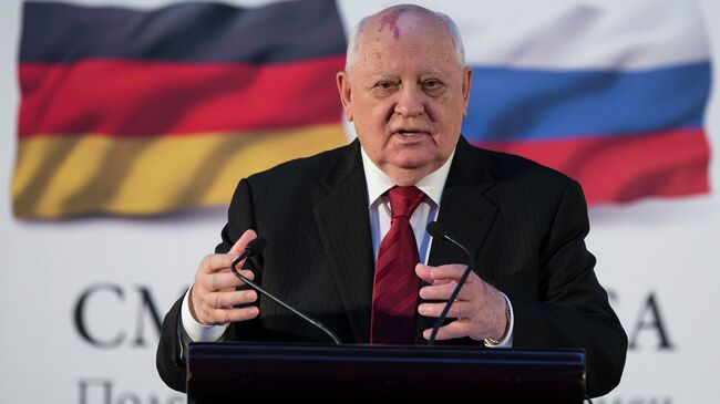 Бывший президент СССР Михаил Горбачев на фоне флагов России и ФРГ