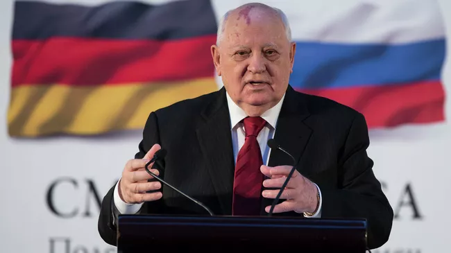 Бывший президент СССР Михаил Горбачев на фоне флагов России и ФРГ Бывший президент СССР Михаил Горбачев на фоне флагов России и ФРГ