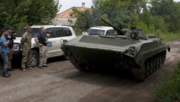 Представители ОБСЕ и журналисты наблюдают за отводом военной техники ДНР на окраине Дебальцево. Архивное фото