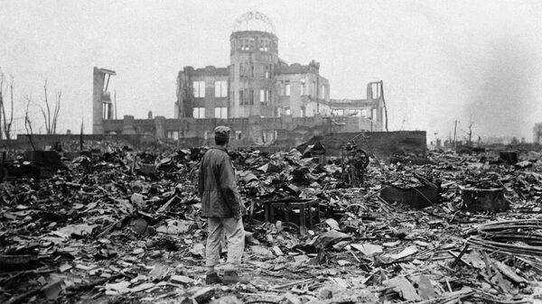 Журналист осматривает руины бывшего кинотеатра спустя месяц после бомбардировки Хиросимы, Япония. 8 сентября 1945. Архивное фото