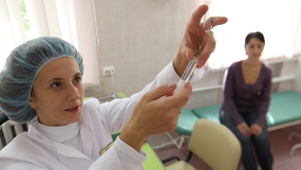 Медсестра набирает лекарство в шприц для укола. Архивное фото