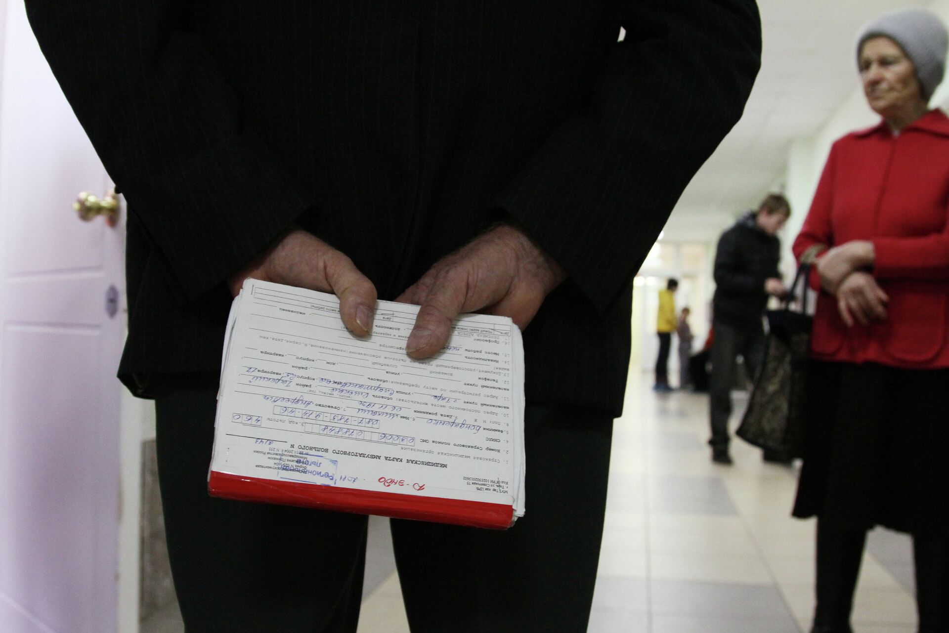 Пожилой мужчина держит в руках медицинскую карточку в одной из поликлиник города Омска - РИА Новости, 1920, 02.12.2021