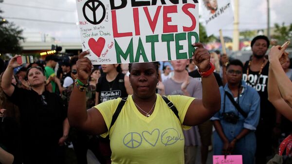 Женщина держит плакат с надписью Black lives matter (Жизни чернокожих важны) во время акции протеста в Майами. Архивное фото