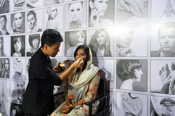 Посетительнице Недели моды в Бангалоре делают макияж