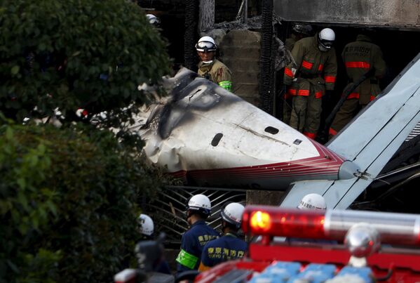 Пожарные и спасатели на месте крушения легкомоторного самолета в городе Тёфу, Япония