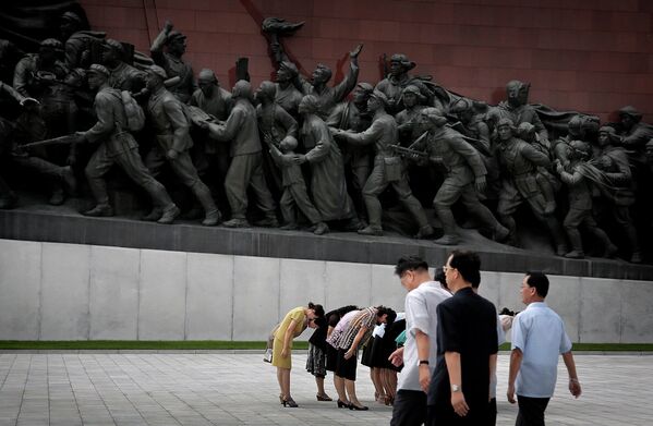 Жители Пхеньяна возле памятника Ким Ир Сену и Ким Чен Иру, КНДР