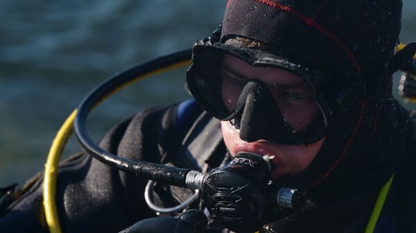 Дайвер погружается под воду в дайвинг-центре Три измерения на озере Байкал