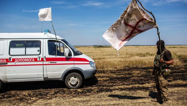 Украинский военный с белым флагом во время передачи убитых на нейтральной территории вблизи поселка Диброво