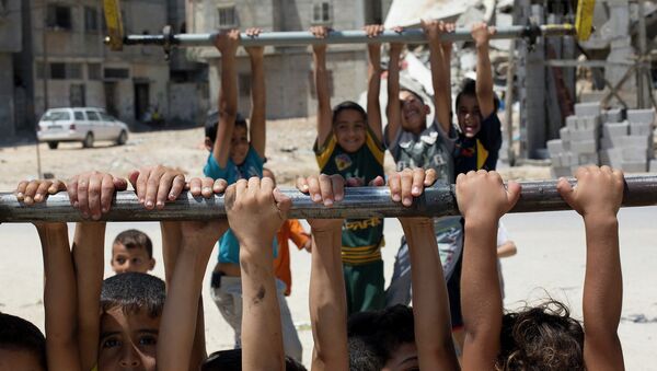 Палестинские дети играют возле разрушенных домов на севере Сектора Газа. Архивное фото